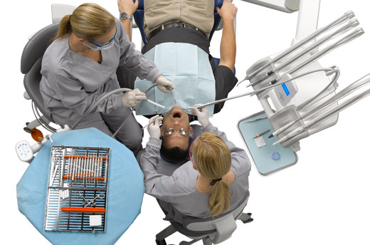 Dentist and assistant use dental delivery system with patient